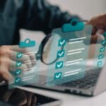 person looking at laptop with magnifying glass